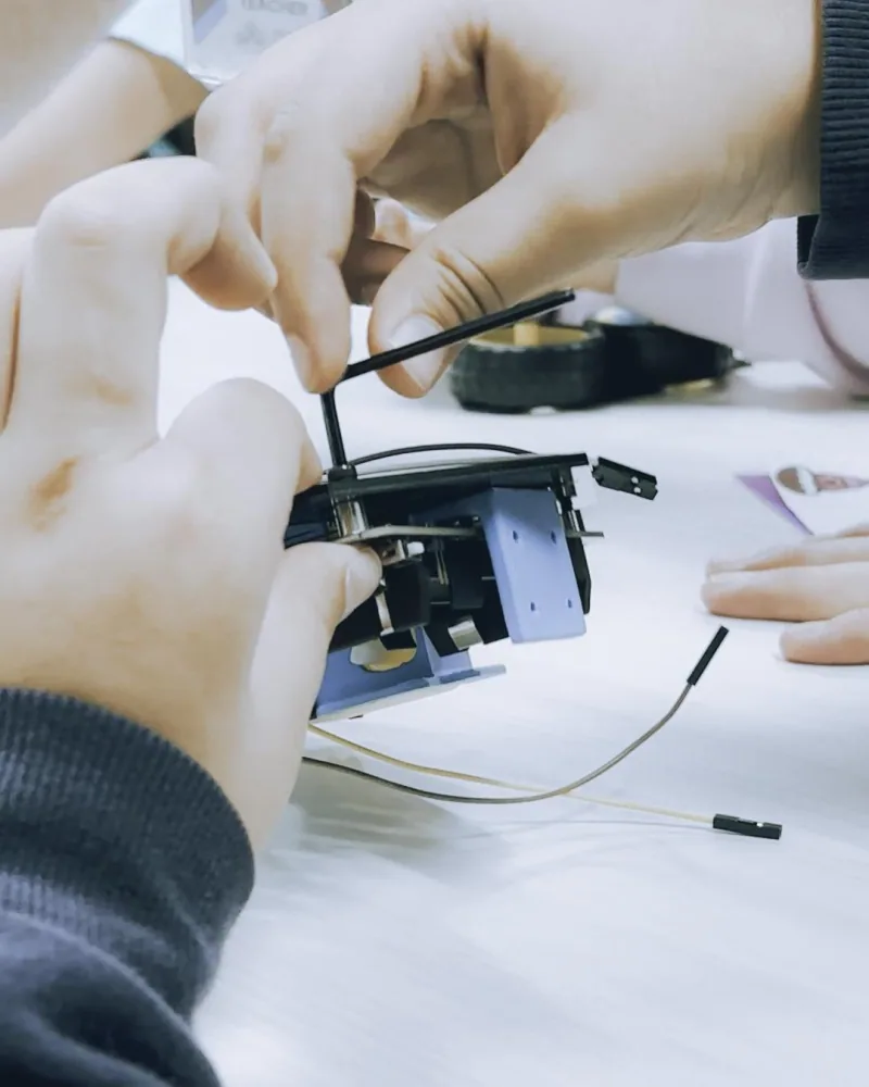 Hands assembling fabricated and electronic components onto a robot frame